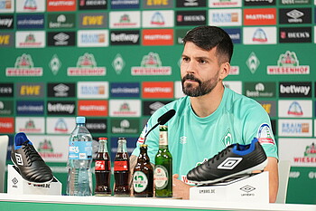 null Anthony Jung bei der Mixed Zone vor einem Mikrofon.