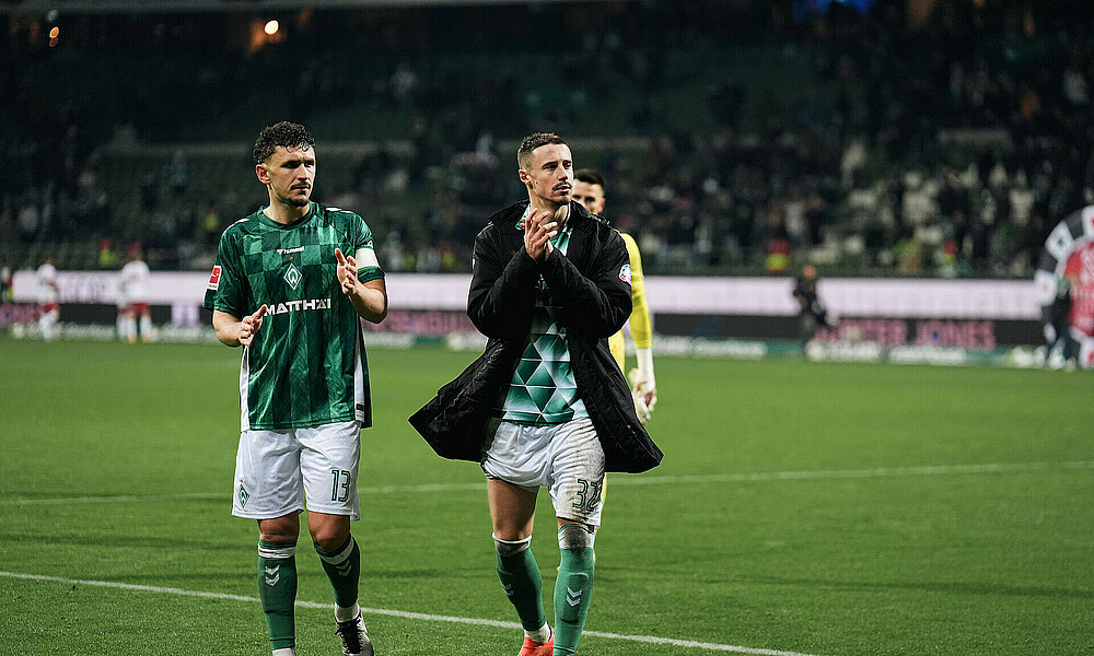 null Milos Veljkovic mit Marco Friedl auf dem Platz im Trikot.