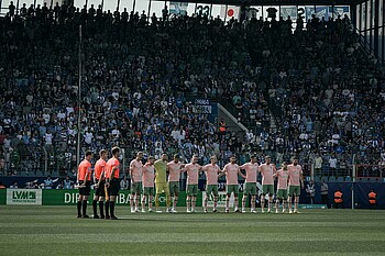 Die Werder-Spieler stehen Arm in Arm zusammen.
