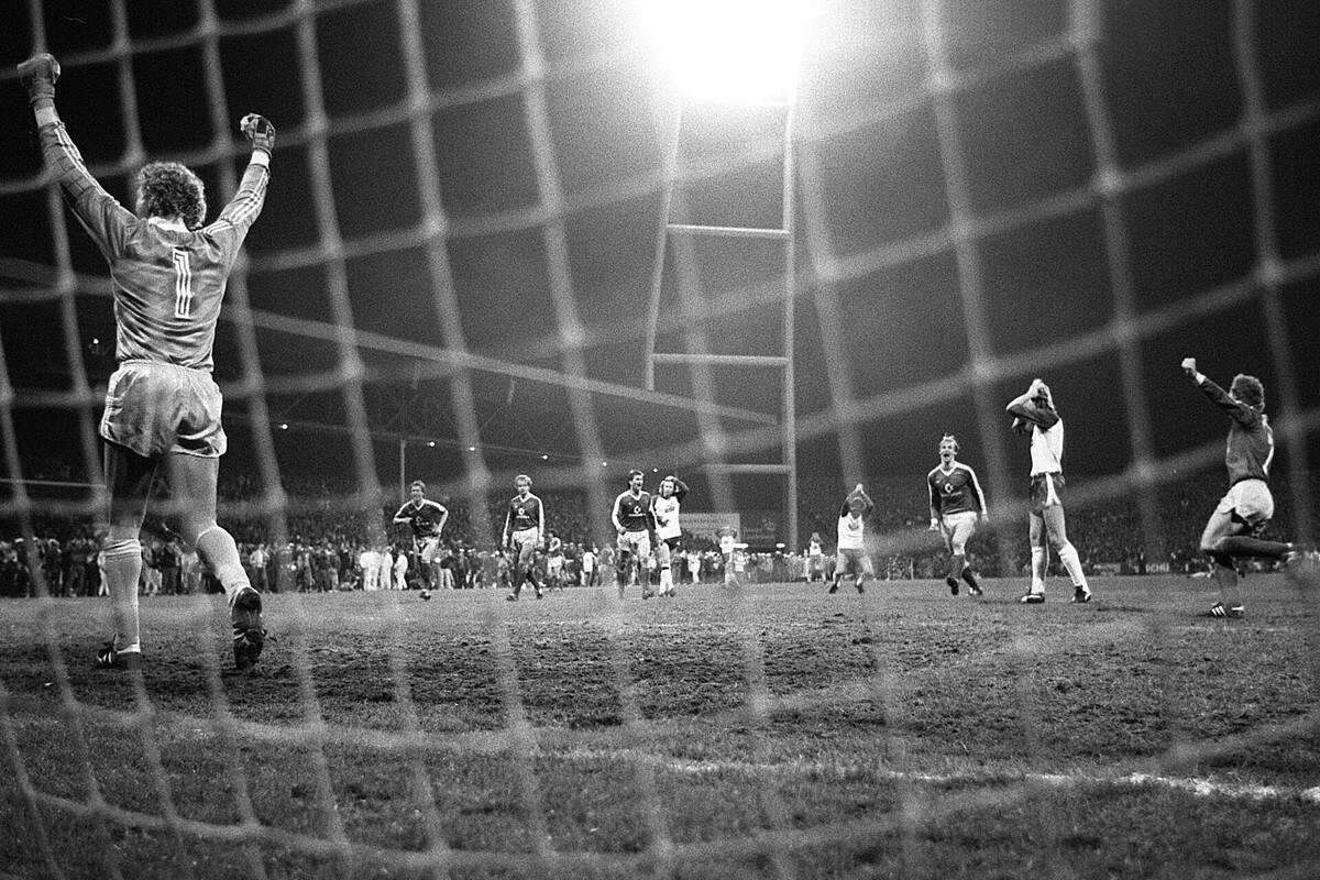 Bayern-Keeper Jean-Marie Pfaff streckt die Fäuste in die Höhe, Michael Kutzop hat die Hände über dem Kopf zusammengeschlagen. Im Hintergrund brennt das Flitlicht.