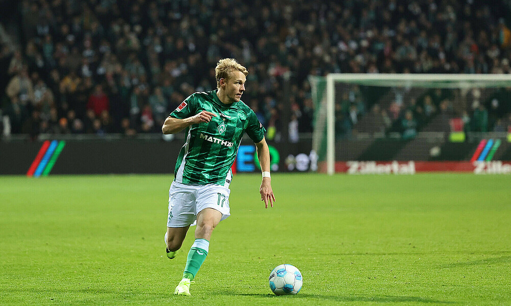 Marco Grüll dribbelt auf dem Rasen im Spiel mit dem Ball am Fuß.