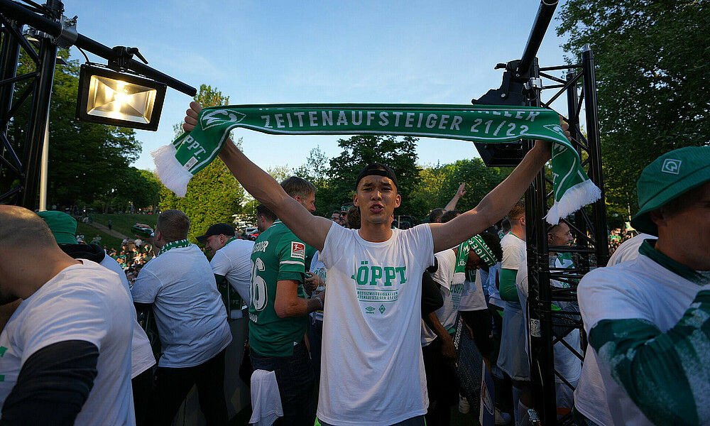 Werder-Torhüter Mio Backhaus hält den Aufstiegsschal über seinen Kopf.