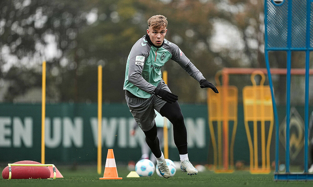 Keke Topp mit langen Werder-Trainingsklamotten und Handschuhen zieht einen Sprint an