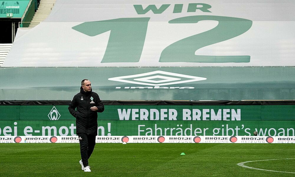 Ole Werner bei einem Geisterspiel vor einem Banner mit der Aufschrift 