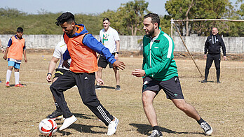 Lukas Godula vom SV Werder spielt Fußball mit anderen Teilnehmer:innen.
