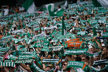 null Werder-Fans in der Ostkurve halten ihren Schal hoch