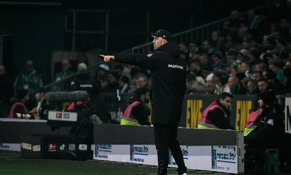 Ole Werner streckt den Arm aus und zeigt in eine Richtung