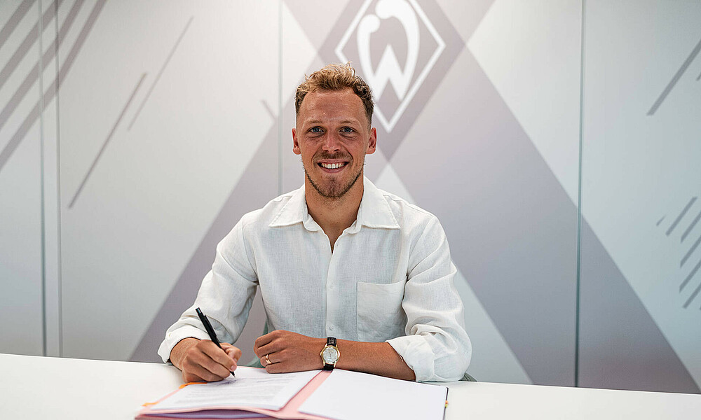 Senen Lynen bei der Vertragsunterschrift lächelt in die Kamera