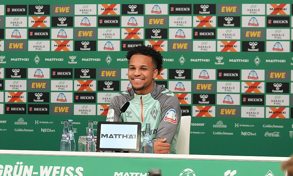 Felix Agu lächelt und blickt nach vorne auf dem Podium bei der Mixed Zone