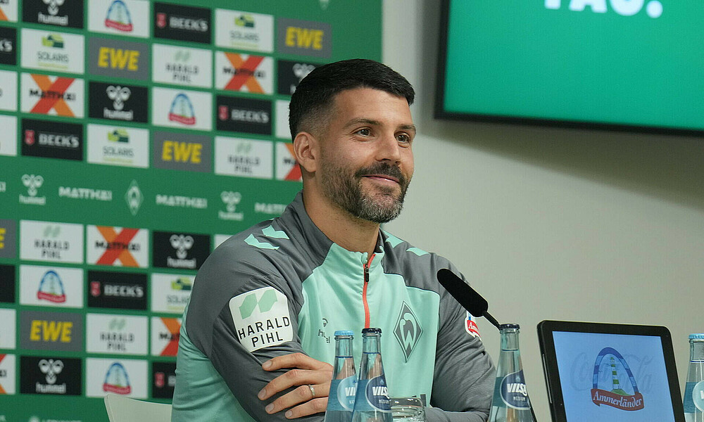 null Anthony Jung lächelt leicht in der Mixed Zone im Weserstadion.