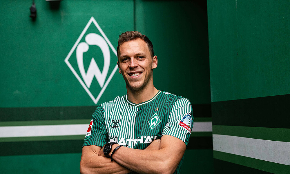 null Senne Lynen in einem Werder-Trikot mit verschränkten Armen.