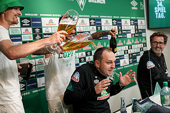 null Die Werder-Spieler übergießen Trainer Ole Werner bei der Pressekonferenz mit Bier.
