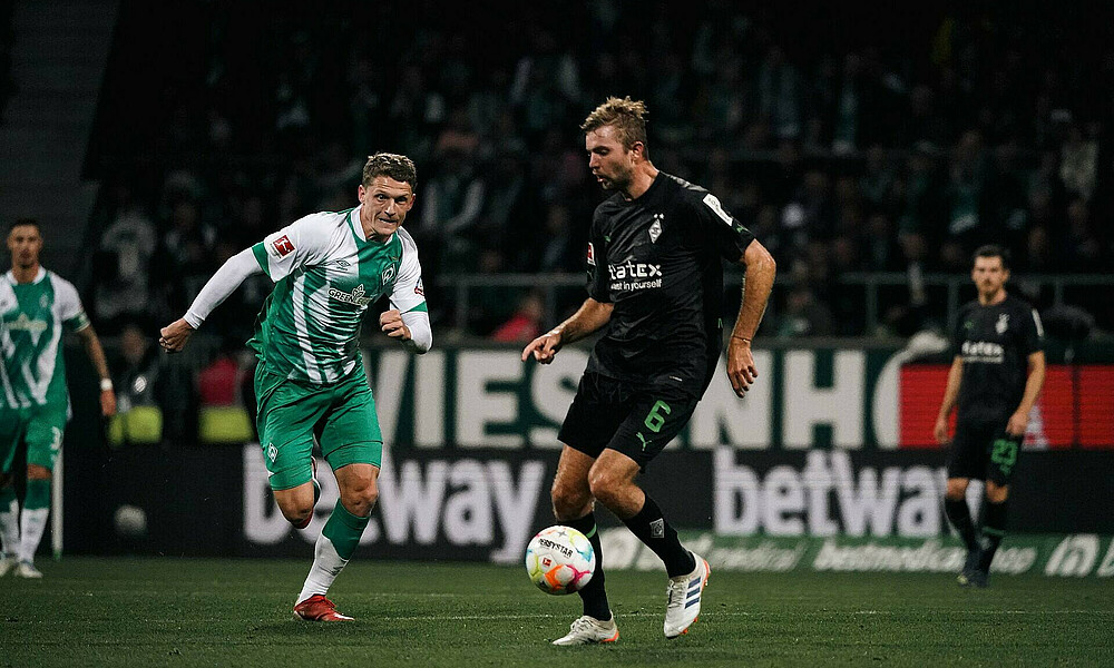 null Jens Stage mit scharfem Blick auf den Ball, den Christoph Kramer führt.