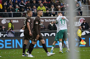 Niclas Füllkrug und Marvin Ducksch umarmen sich nach dem Tor, zwei St. Pauli Spieler im Vordergrund.