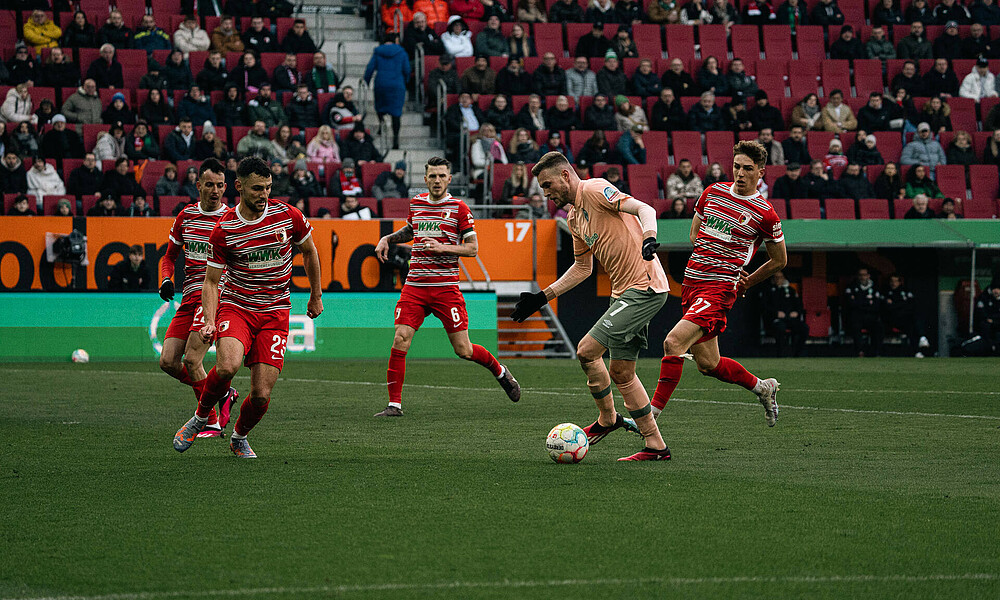 Marvin Ducksch mit Ball am Fuß mit mehreren Gegenspielern. 