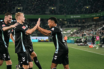 Felix Agu klatscht mit seinen Mitspielern nach seinem Tor in Wolfsburg ab
