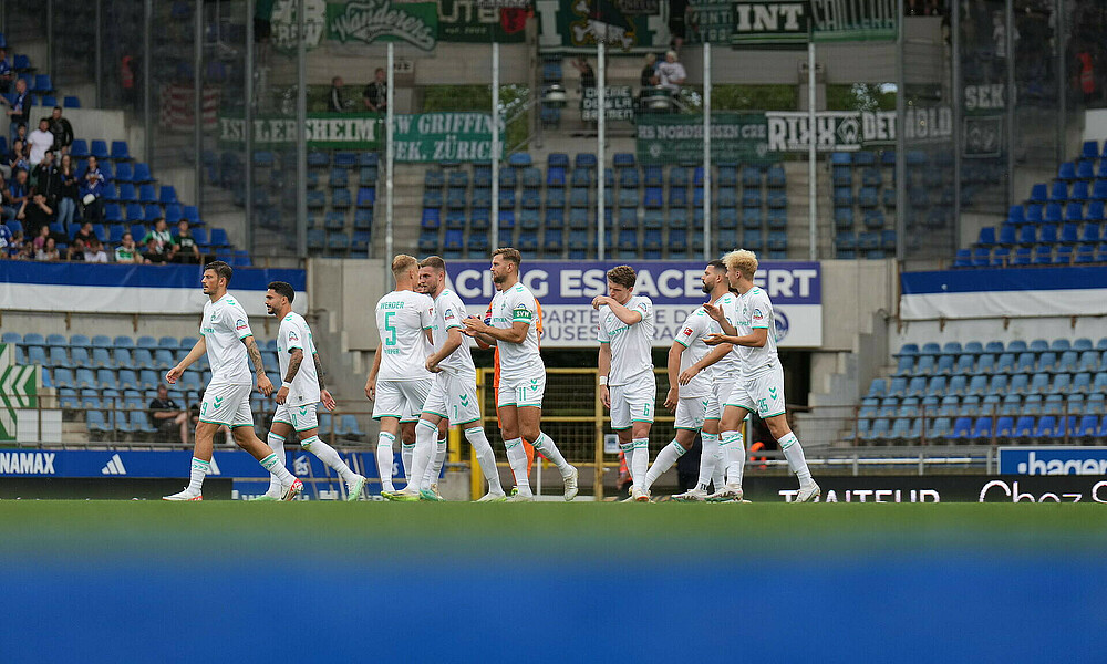 Die Mannschaft klatscht sich auf dem Feld ab. 