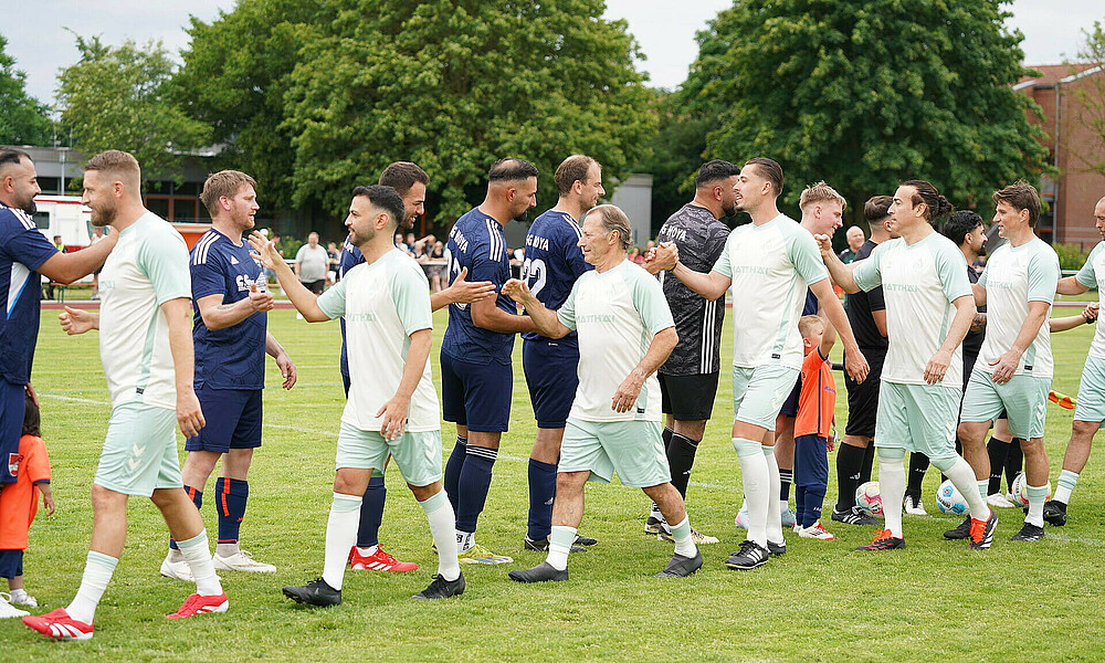 Die WERDER LEGENDEN klatschen mit Hoya vor Anpfiff ab.