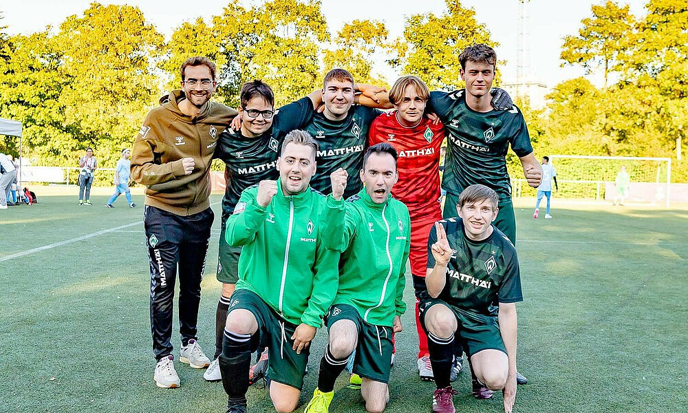 Eine Menschengruppe, die alle Werder Trikots tragen.