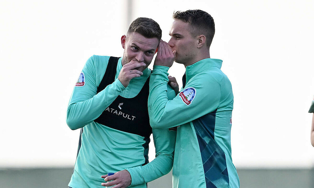 Niklas Schmidt flüstert Marvin Ducksch etwas ins Ohr.