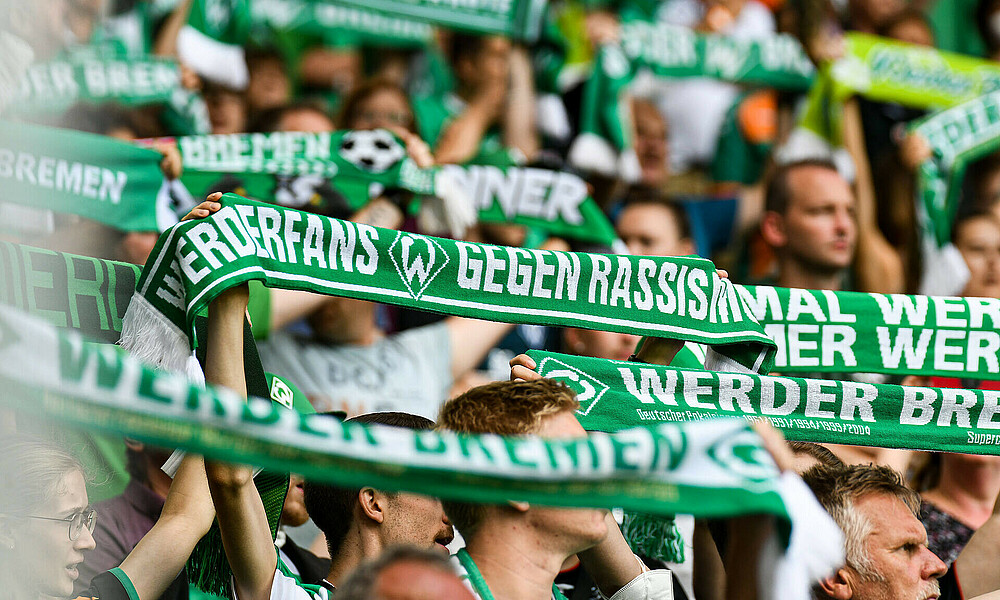 Fans halten ihre Werder Schals hoch
