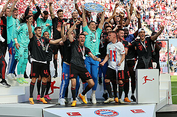 null Die Bayern halten in Köln die Schale in die Luft.