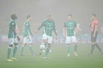 null Die Spieler warten im Nebel mit dem Ball.
