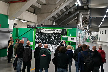 Zahlreiche Menschen stehen vor der Gedenktafel und hören Dr. Hubertus Hess-Grunewald zu.