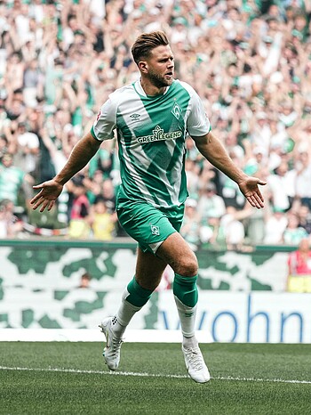 null Niclas Füllkrug läuft mit ausgebreiteten Armen.