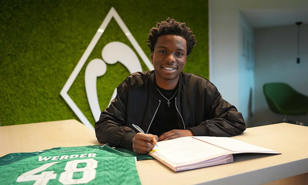 Wesley Adeh unterschreibt seinen Vertrag. 