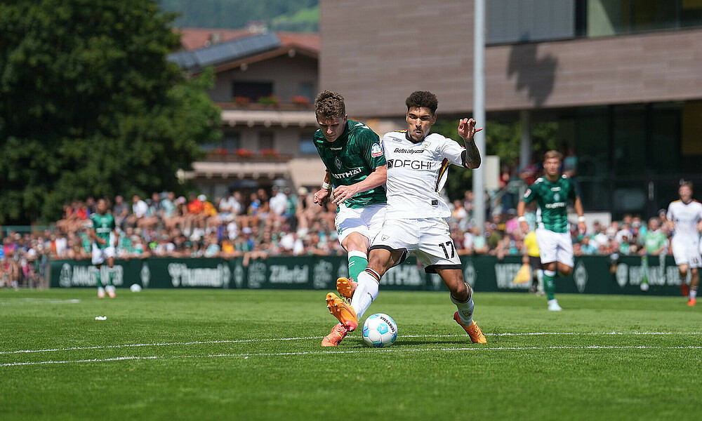 Jens Stage beim Schussversuch, sein Gegenspieler ist an ihm dran. 