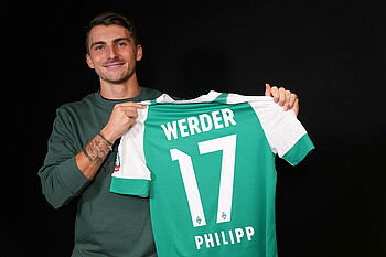 Maximilian Philipp hält sein Trikot in die Kamera. 