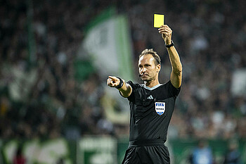 Bastian Dankert zeigt eine Gelbe Karte. 