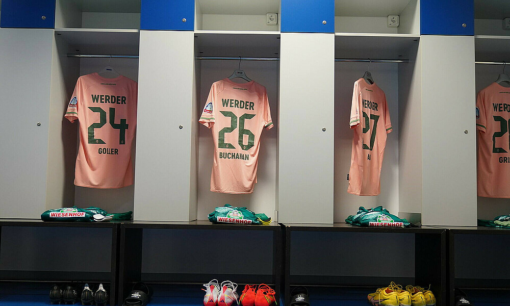 Trikots von Werderspielern hängen vor Spielbeginn in der Kabine.