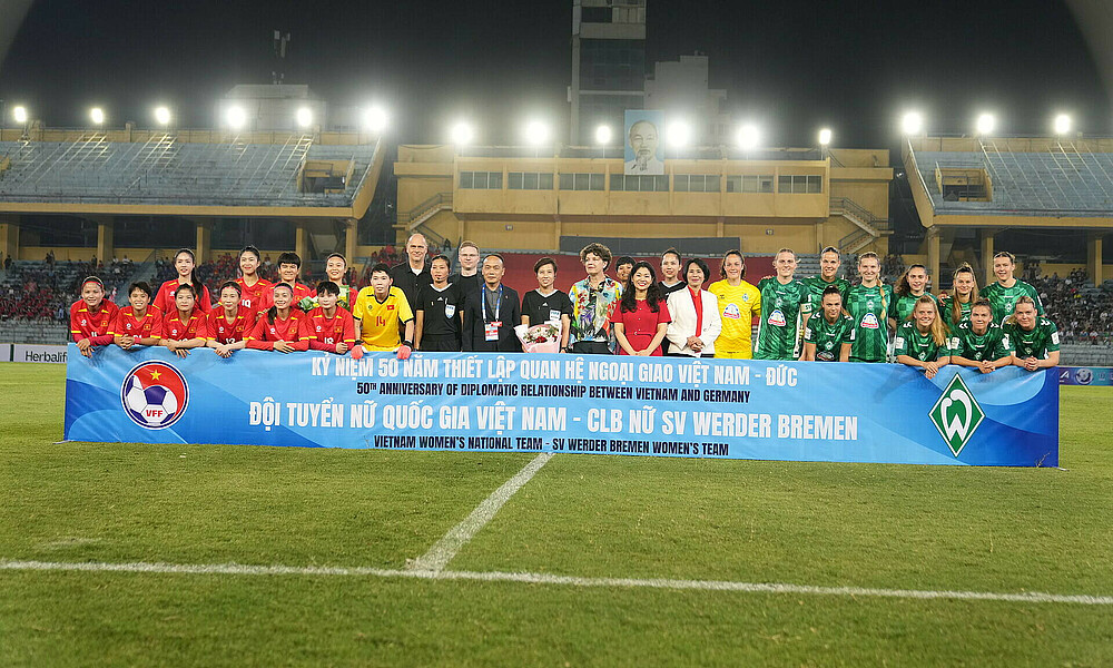Die Teams vor dem Anpfiff mit einem Banner. 