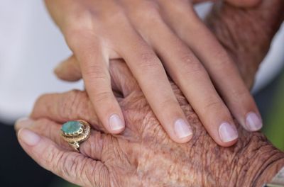 Gesund altern - Longevity: junge Hand auf einer älteren Hand