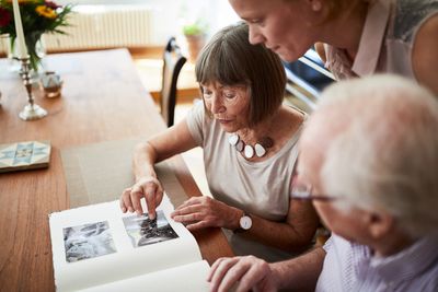 Unternehmen zu Alzheimer & Demenz: Senioren blaettern im Fotoalbum