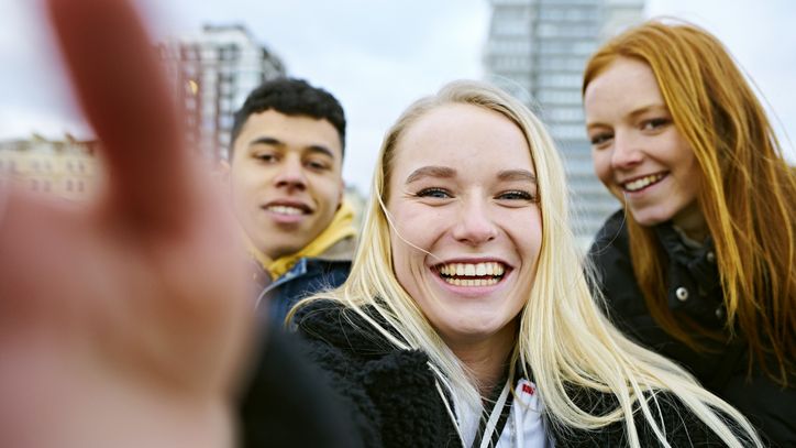 Fondssparen: Zwei Mädchen und ein junger Mann lachen in Kamera