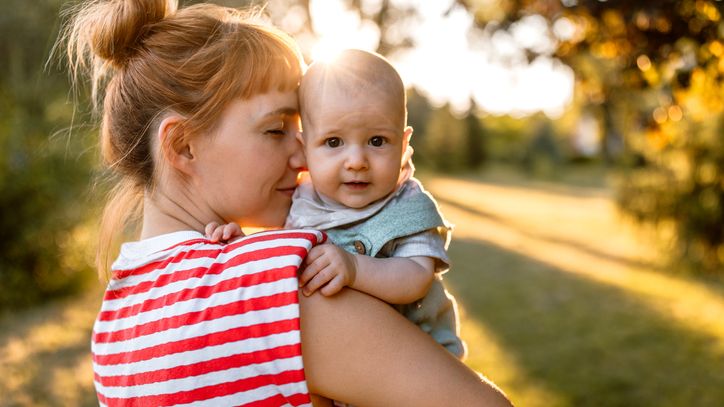 Alles rund um Fonds Alles rund um Fonds: Junge Mutter im roten Ringelshirt hält Baby im Arm