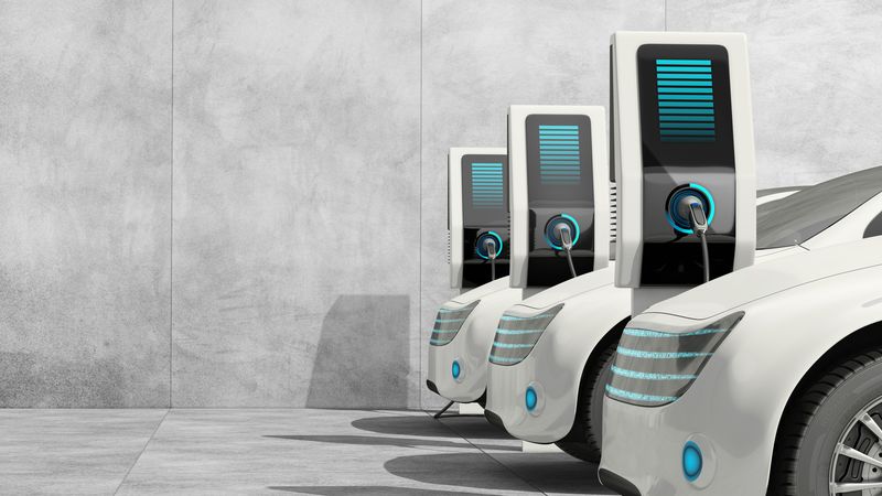 e-mobility Nachhaltig investieren: 3 weiße Elektroautos, die gerade aufladen