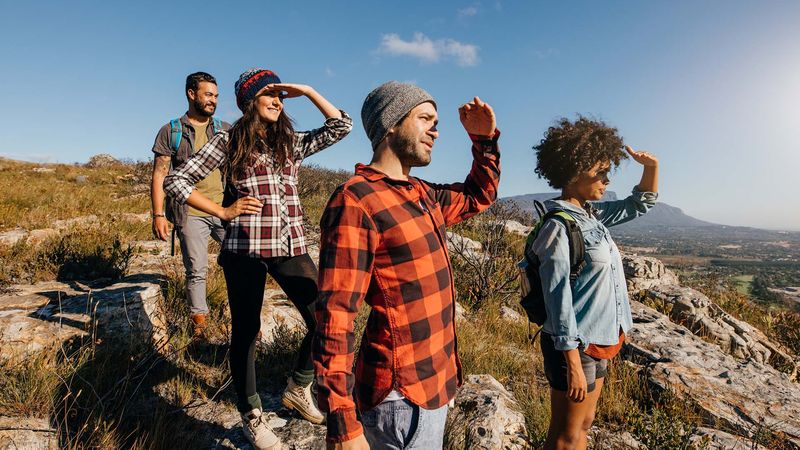Investmentprozess Nachhaltig investieren: Eine Gruppe Wanderer blickt gegen die Sonne in die Ferne
