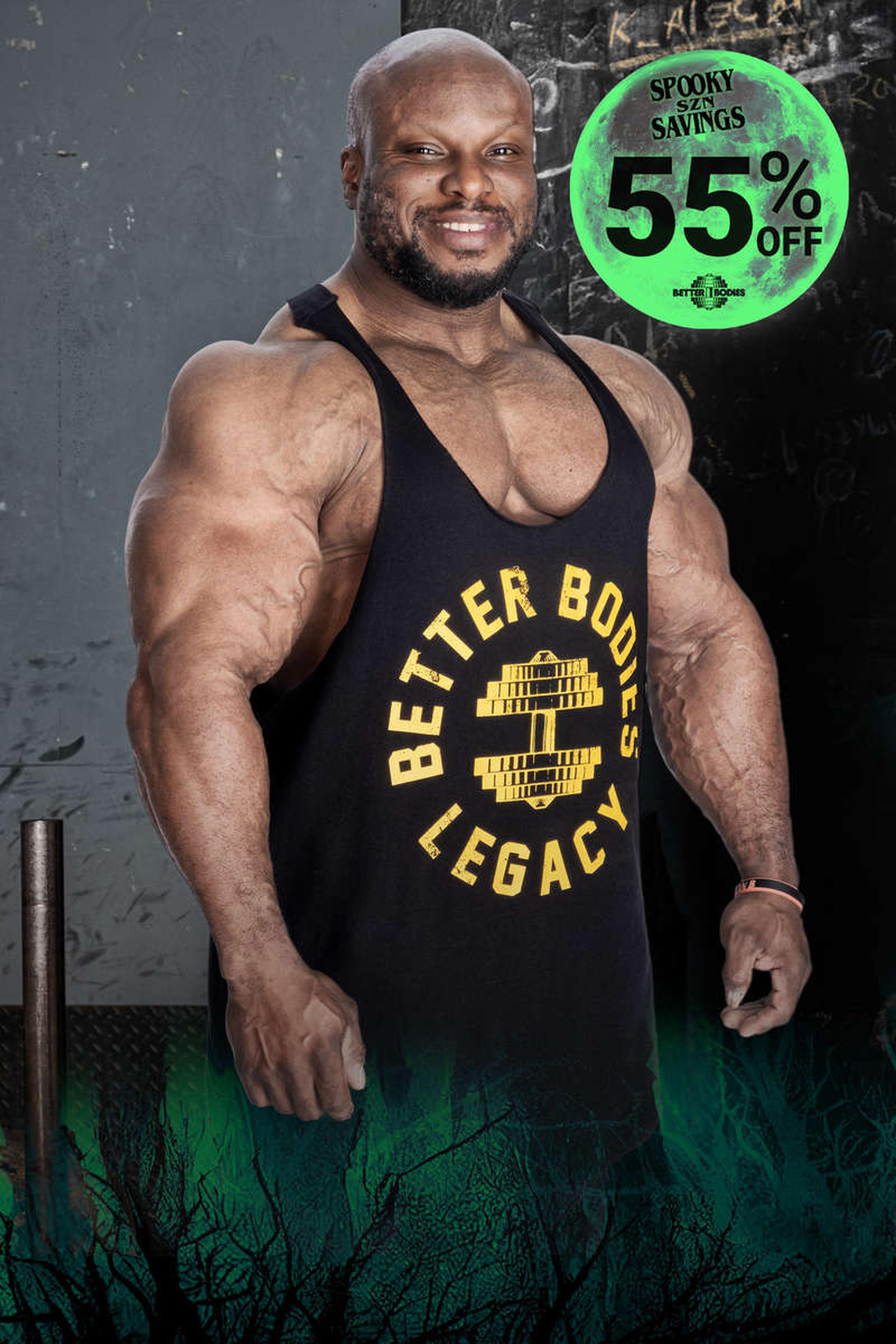 Muscular man in a black tank top with "Better Bodies Legacy" logo, standing in a gym. Green "Spooky Savings 55% Off" text in the corner.
