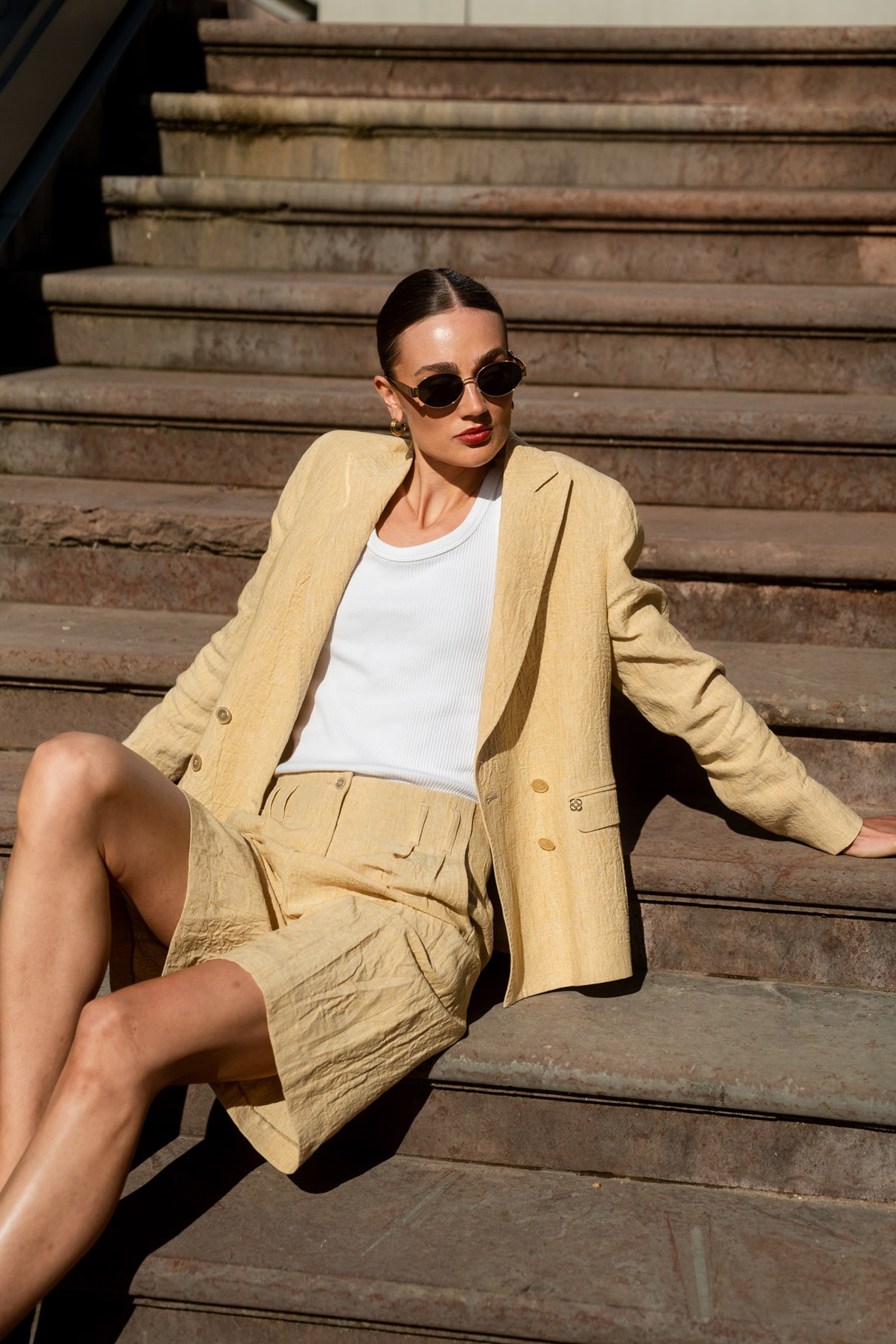 Women i yellow jacket sitting on a stair