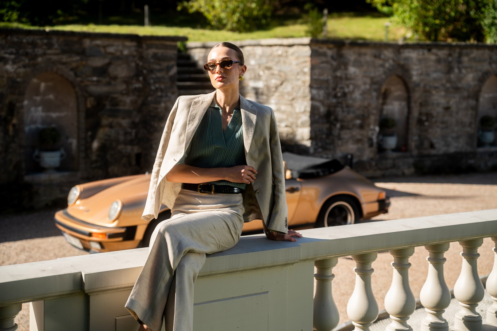 Women i linnen jacket and knitted shirt sitting on a rail