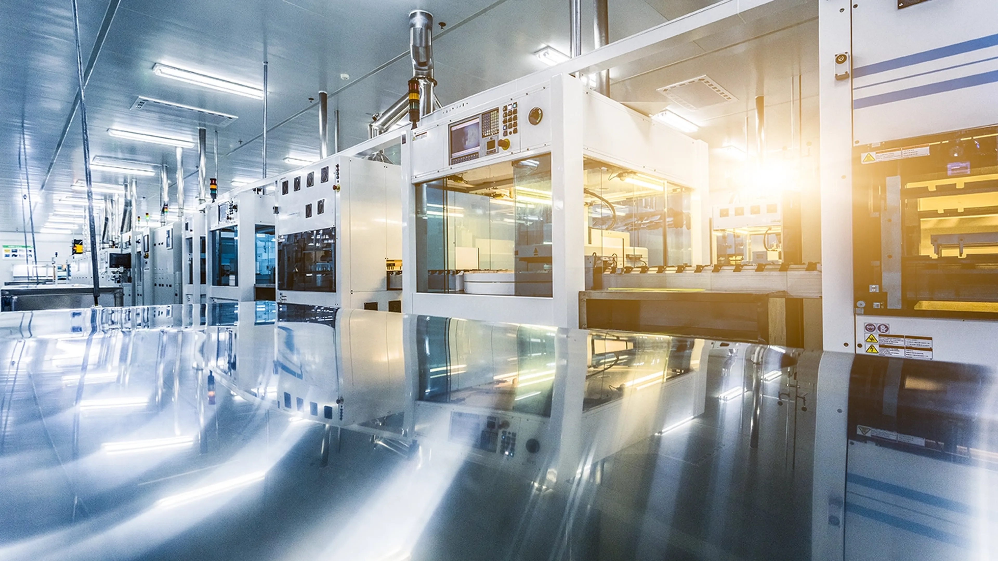Modern manufacturing facility with automated machinery, reflective surfaces, and bright lighting, highlighting an industrial production line.