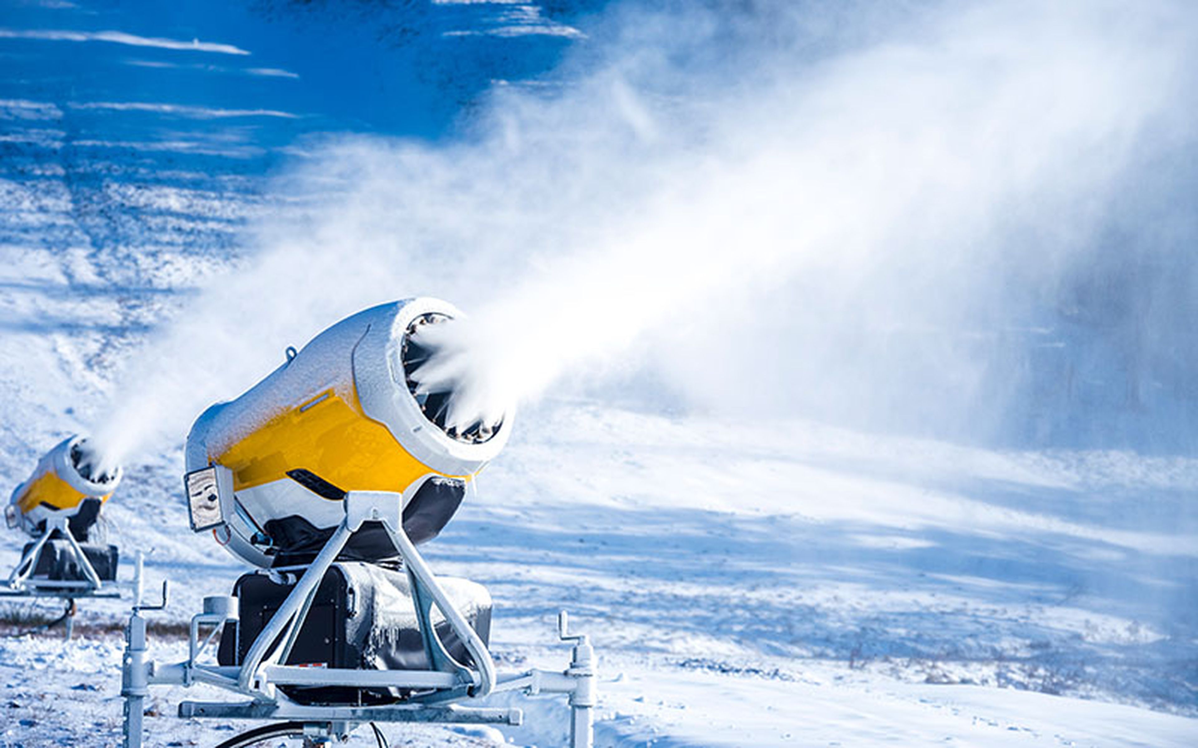There is a lot more to snowmaking machines than meets the eye. First, a "nucleator" sprays an ultra-fine cloud of water particles (around 30 to 70 microns in size) into the air. When these freeze into tiny ice crystals, larger water droplets from a mister attach to them, building up fluffy snowflakes.