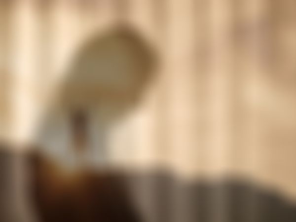 Silhouette einer Person mit erhobenen Armen innerhalb der Silhouette einer anderen Person, vor dem Hintergrund eines Sonnenuntergangs mit Bergen.