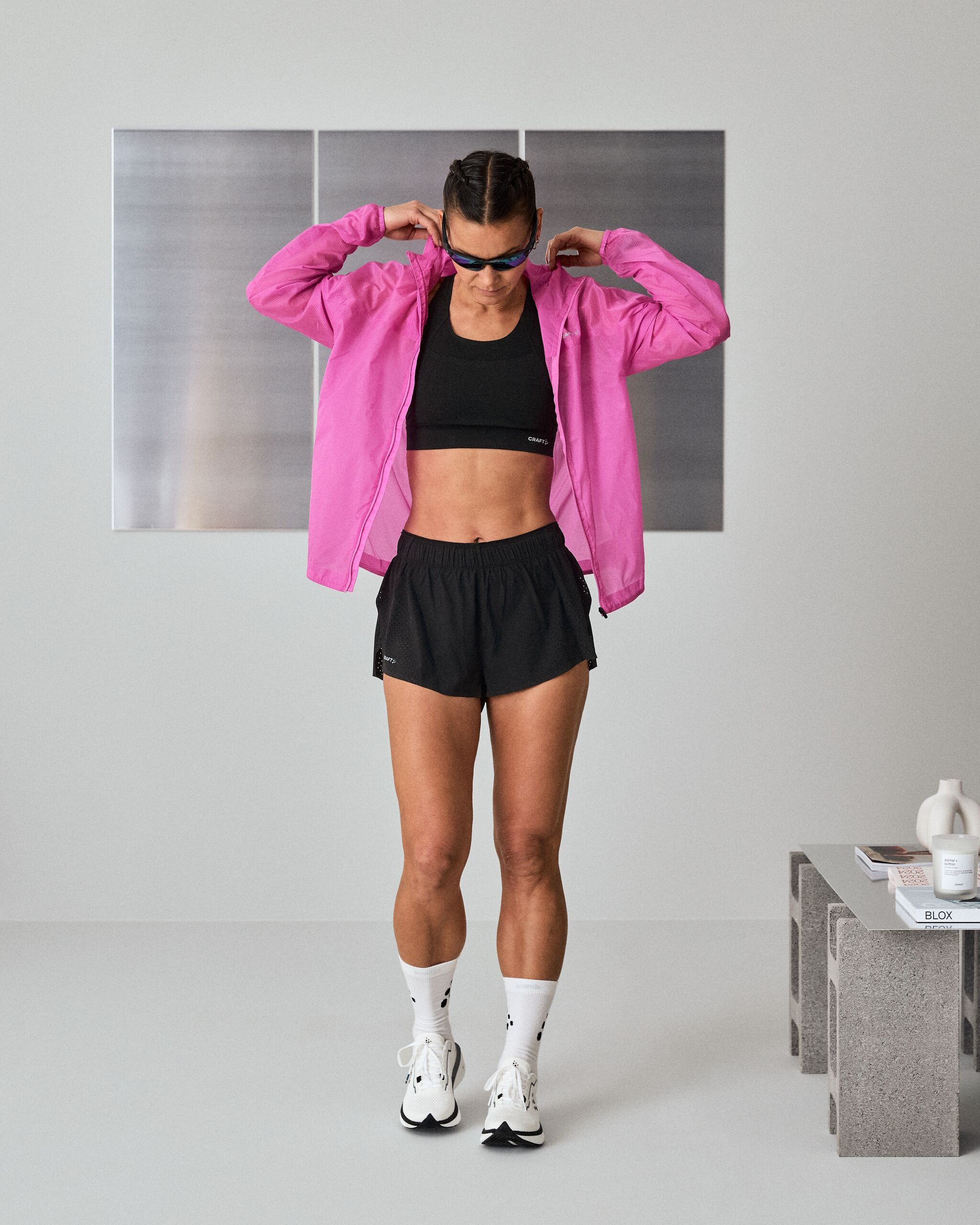 Kvinne som tar på seg en rosa løpejakke