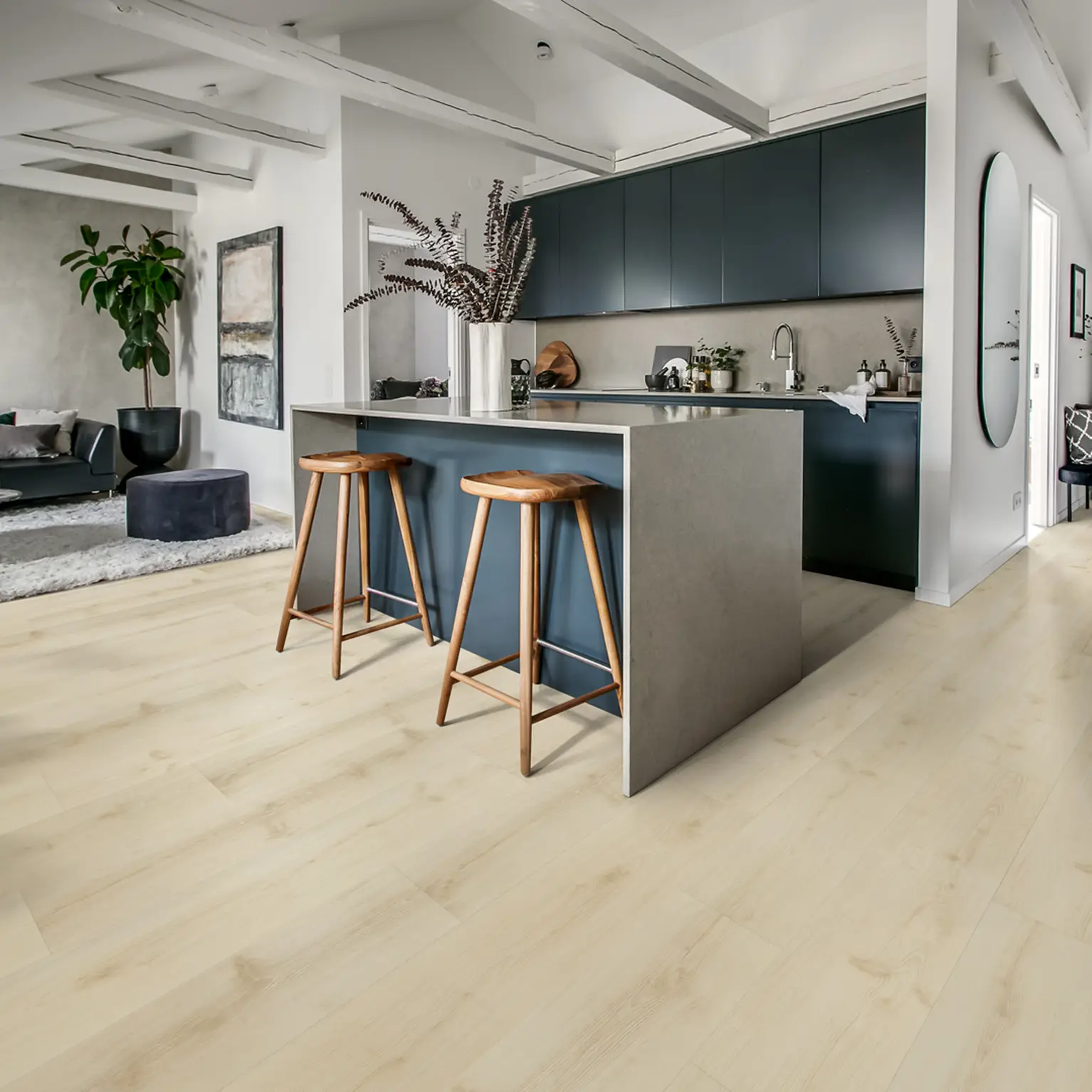 Contemporary kitchen with light wood flooring, dark cabinets, and wooden barstools.