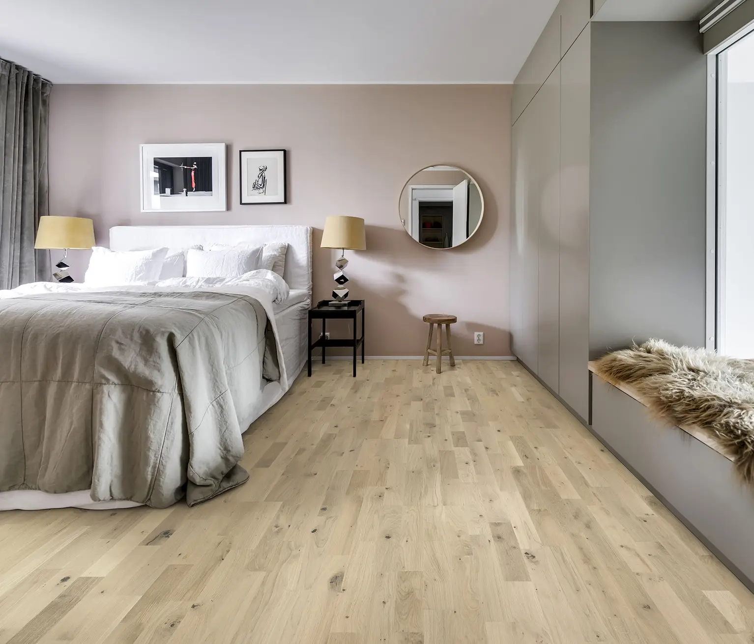 Neutral-toned bedroom featuring light oak flooring and soft furnishings.